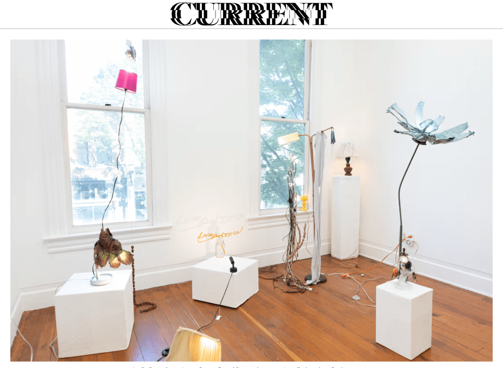 A screenshot of a website with the tittle CURRENTS in a blurry font. Below is an installation of sculptures in a gallery.